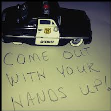 Police car and text: "Come out with your hands up"