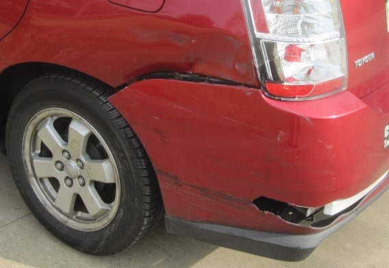 Photo showing collision damage to left rear of auto